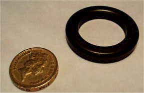 photograph showing a Ferrite ring compared in size to a pound coin and that the ferrite ring is almost larger enough to fit over the pound coin